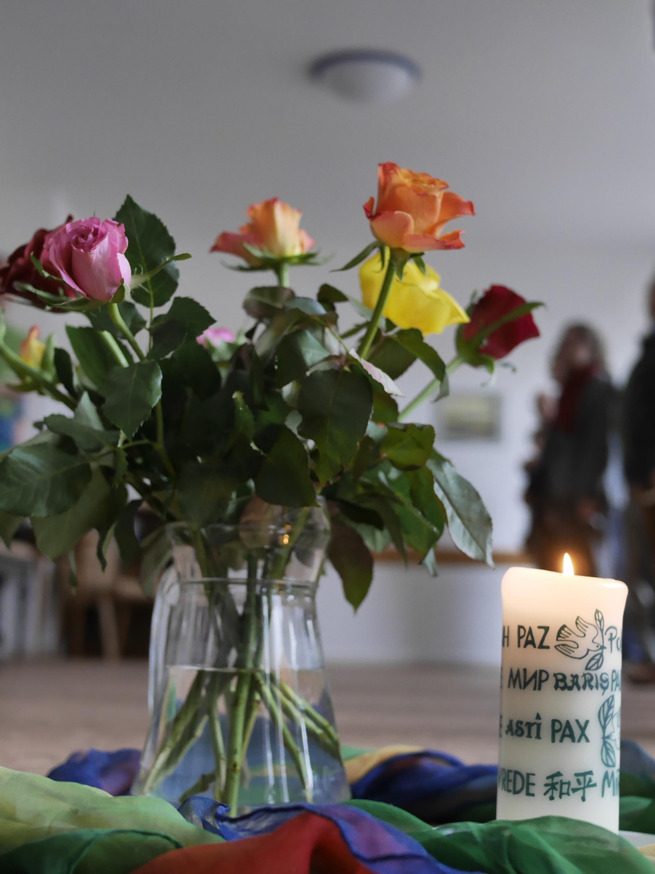 Blumenvase mit brennender Friedenskerze